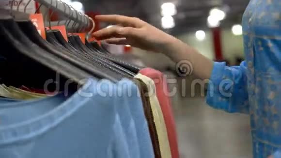 商店里挂在木制衣架上的时装夹克挑选衣服的人视频的预览图