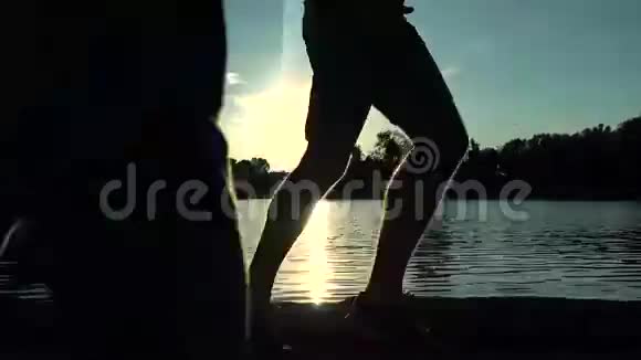 男子跑步腿日落轮廓靠水颜色分级4K型安定片视频的预览图