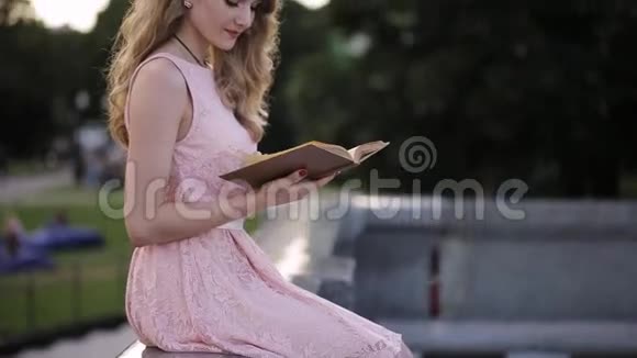 美丽的女孩在公园看书梦想着爱情视频的预览图