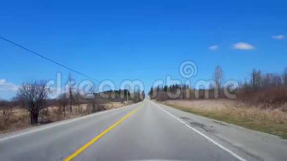 春日期间驾驶农村沿着美丽的阳光路的司机视角视频的预览图