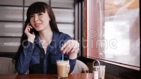 小女孩在咖啡馆里用智能手机聊天视频的预览图