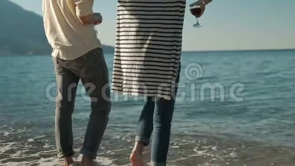 男人和女人站在海滩上戴着酒杯红酒在夏天视频的预览图