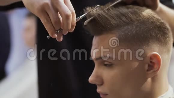 发型师用剪刀剪年轻人的头发视频的预览图