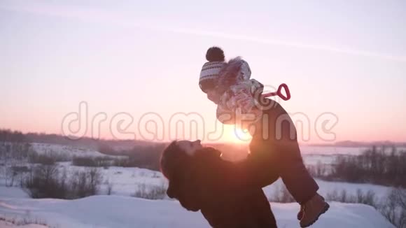 一个带着孩子在冬季公园玩耍的小女孩在新鲜空气中游走日落视频的预览图