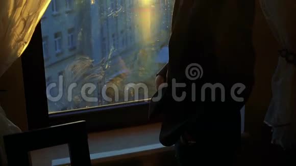 帅哥用电话在窗户窗帘的背景下微笑视频的预览图