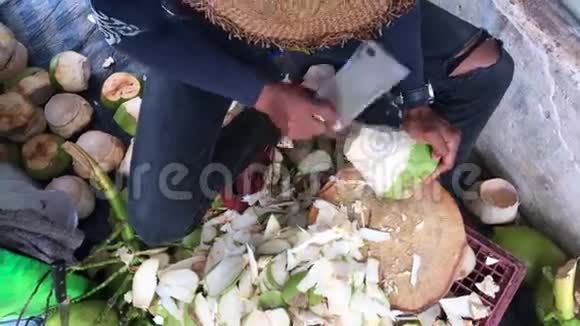 街头卖椰子的人用斧头砍下年轻的椰子视频的预览图