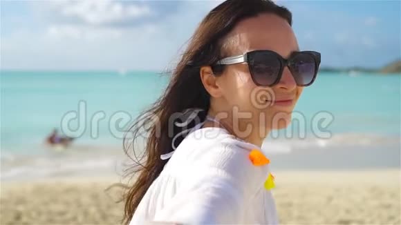 热带白色海滩上年轻女子的后景流动人口视频的预览图