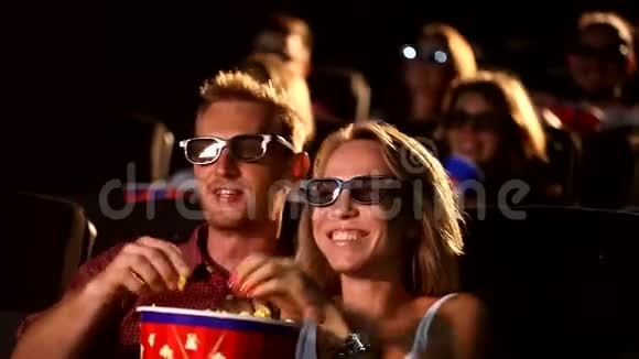 一群年轻快乐迷人兴奋的男性女性朋友吃爆米花享受3d4d动作电影院视频的预览图