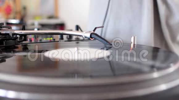 一个音频调音台和一个乙烯基旋转的侧面镜头一个DJ在家里混合音乐DJ在乙烯基上抓挠视频的预览图