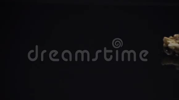 一堆核桃放在黑色反光台上视频的预览图