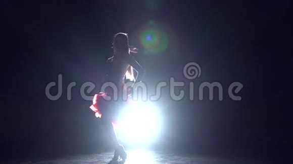 女孩跳舞伦巴在黑暗的背景与灯光照明慢动作视频的预览图
