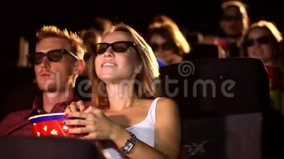 一群年轻兴奋迷人快乐的男性女性朋友吃爆米花享受3d4d动作电影院视频的预览图