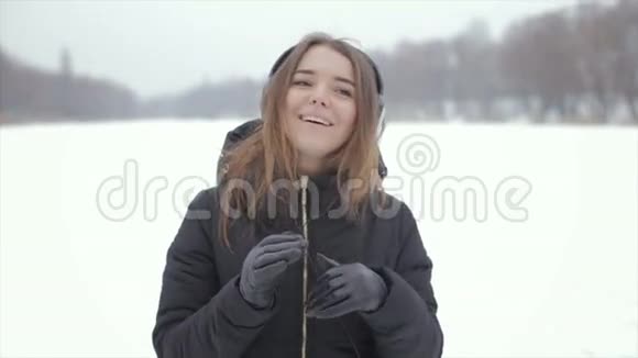 冬天的快乐女孩听着音乐站在雪地里视频的预览图