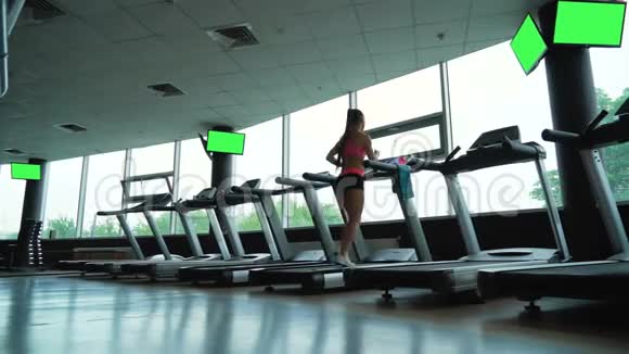 健身俱乐部跑步机上的年轻女子训练视频的预览图