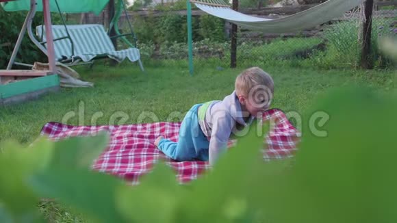 一个小男孩在炎热的夏天在草坪上玩耍孩子玩得开心积极地度过他们的闲暇时间快乐视频的预览图