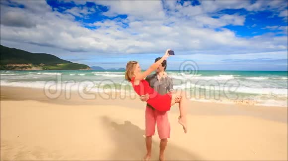 男子手持武器金发女孩在沙滩上做自拍视频的预览图