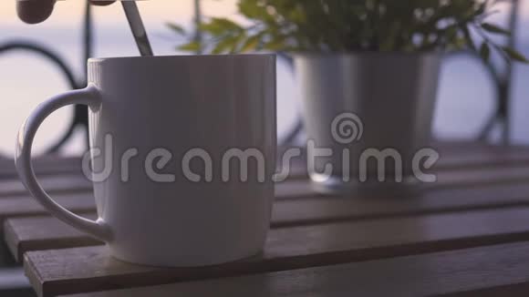 阳光明媚的早晨年轻人在海边喝杯咖啡视频的预览图
