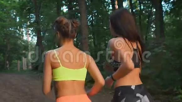 两个健身女孩穿过树林他们练习体育生活方式为了健康和基调视频的预览图