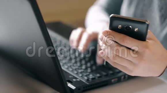 女人正在用笔记本电脑和智能手机工作视频的预览图