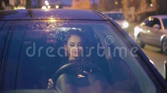 优雅的女士坐在车里用电话视频的预览图