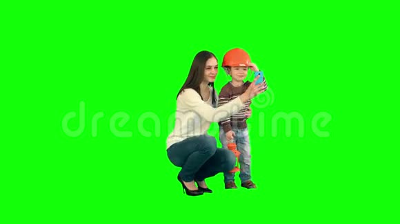 一个男孩和她的母亲在绿色上自拍视频的预览图