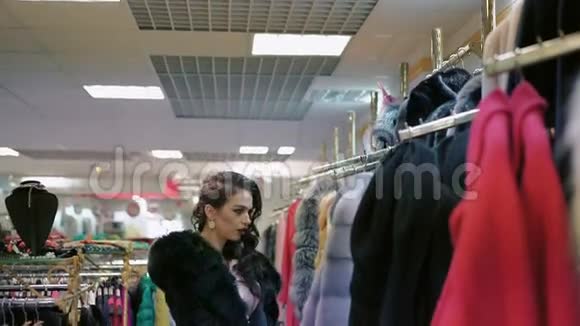 一位优雅的女士在购物中心看着皮大衣视频的预览图