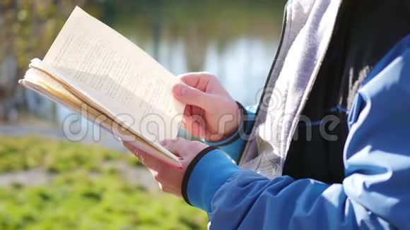 男孩在湖边的秋天公园看书美丽的秋景学校教育视频的预览图