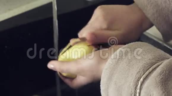 家庭主妇在厨房库存录像中用自来水清洗土豆视频的预览图