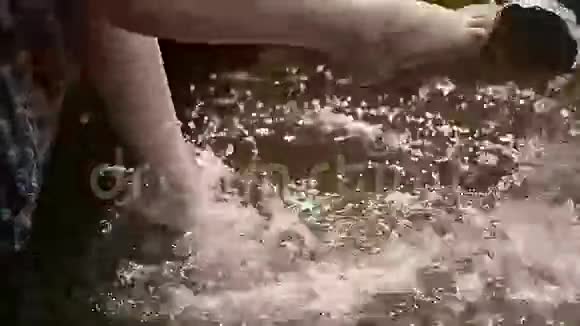 女性的腿在水中摇摆美丽的溅出慢动作视频的预览图