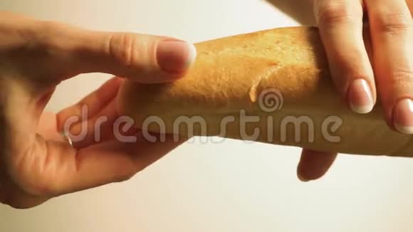 女孩的手用指甲油打破一些新鲜的法国小麦面包视频的预览图