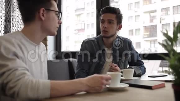 两个朋友坐在咖啡馆里互相聊天视频的预览图