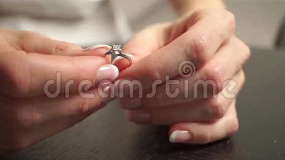 戴着漂亮指甲油的年轻女子手指上戴着钻石戒指视频的预览图