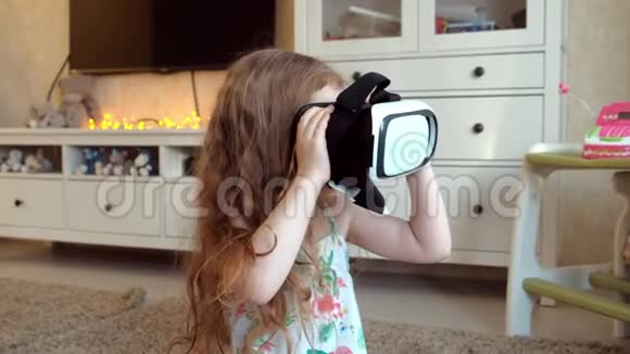 小女孩穿着白色衬衫在家看360视频戴着VR耳机视频的预览图