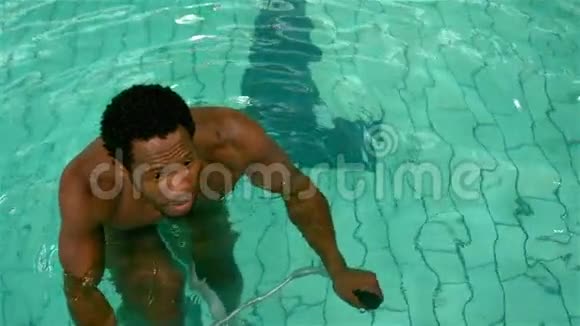 健身男子在游泳池里骑自行车交叉双臂视频的预览图