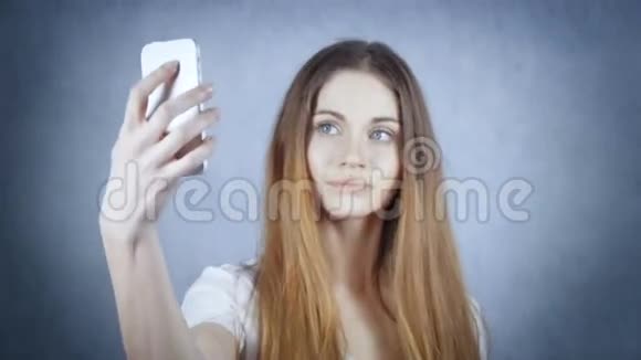 快乐的年轻女性通过她的智能手机在工作室自拍视频的预览图
