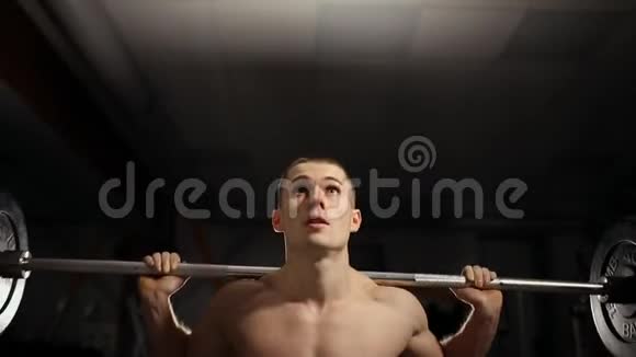 英俊的肌肉男在健身房锻炼蹲视频的预览图