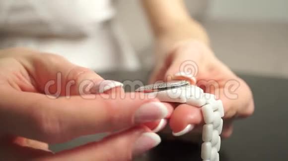 戴着漂亮指甲油的女人把她的白色手表视频的预览图