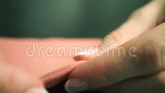 女人用漂亮的指甲油缝制橙色的布宏观视频视频的预览图