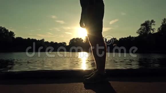 慢动作稳定夹日落公园的跑步者开始沿着堤岸奔跑视频的预览图