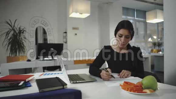 女人在工作吃胡萝卜和苹果片视频的预览图