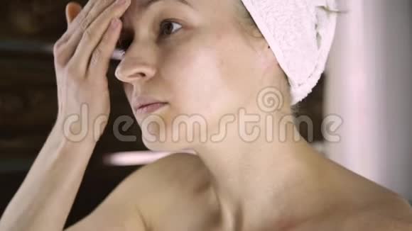美丽的健康女人在毛巾上放保湿霜护肤和家庭水疗视频的预览图