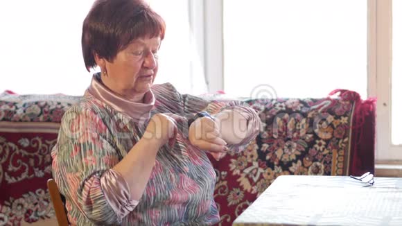 一位老年妇女在智能手表上检查信息她读提醒并说出搜索的短语之后视频的预览图