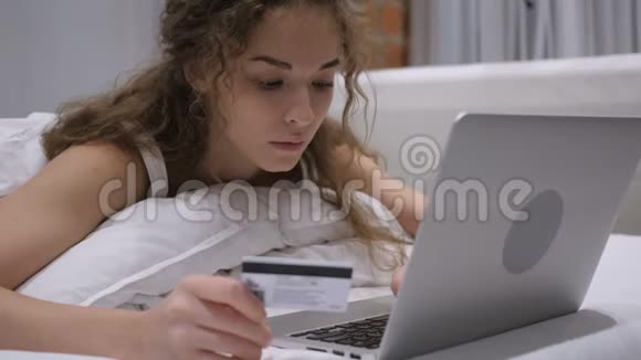 女性在床上成功的网上购物信用卡支付视频的预览图