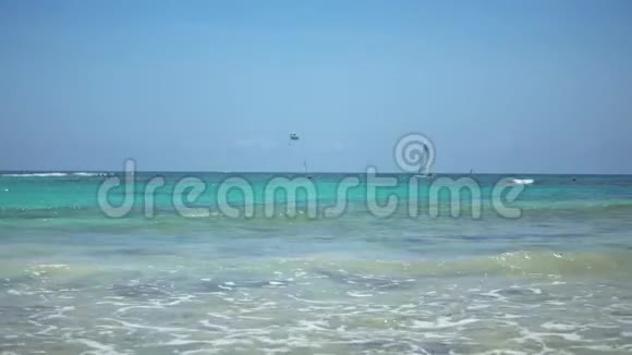 热带海滩景色游客乘坐伞降船帆船在波浪上航行绿松石水视频的预览图