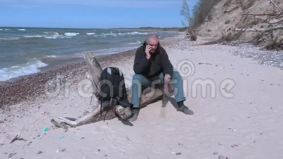 坐在沙滩上打电话的人视频的预览图