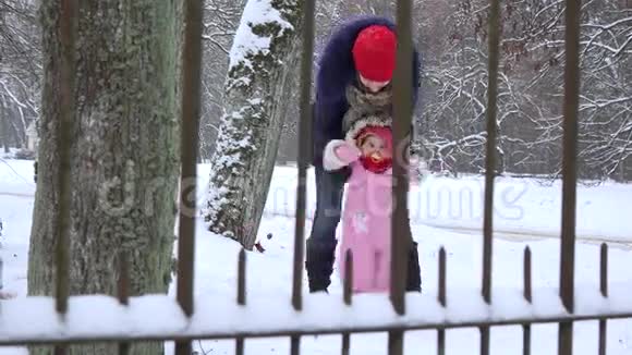 妈妈和宝贝女儿在冬季公园玩得很开心4K视频的预览图