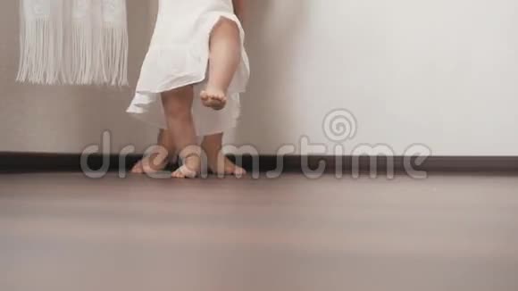 白种人的母亲支持她的小婴儿练习她的第一步视频的预览图