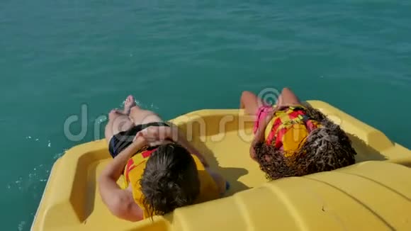 孩子们躺在游艇船海上休息孩子们在海边乘双体船视频的预览图