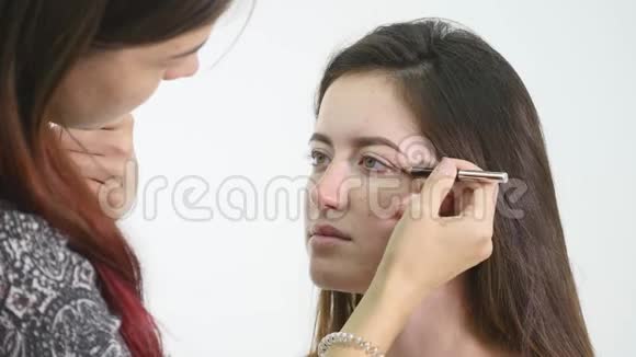 专业化妆师应用眼影模型眼使用特殊的刷子沙龙里的天然化妆美容化妆视频的预览图