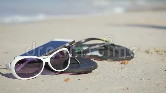 沙滩拖鞋太阳镜沙滩手机慢运动中的旅行概念1920x1080视频的预览图